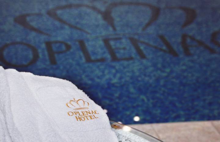 Beli peškir sa zlatnim logotipom Hotela Oplenac pored bazena